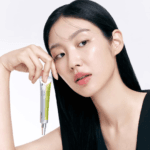 Model holding Celimax Vita-A Retinal Shot Tightening Booster 15ml showcasing premium Korean skincare for smoother and firmer-looking skin.