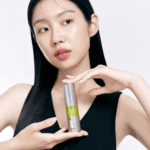 Model holding Celimax Vita-A Retinol Shot Tightening Serum 30ml demonstrating Korean anti-aging skincare.